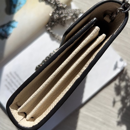 Black wallet with beige interior on a light wooden surface