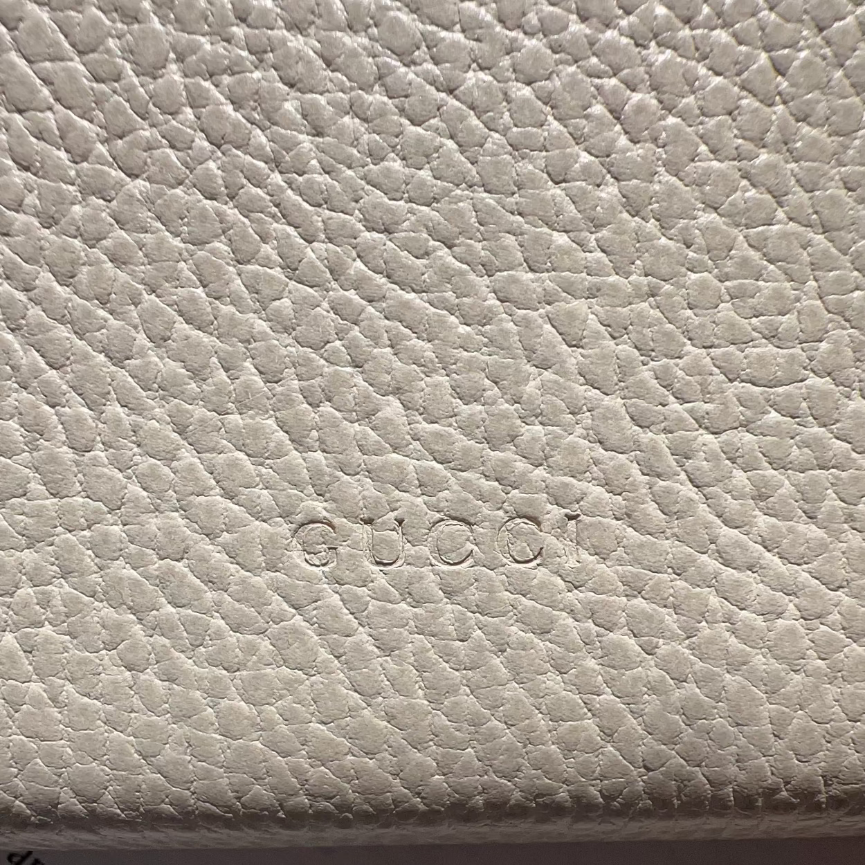 Close-up of a textured beige surface with text partially visible.