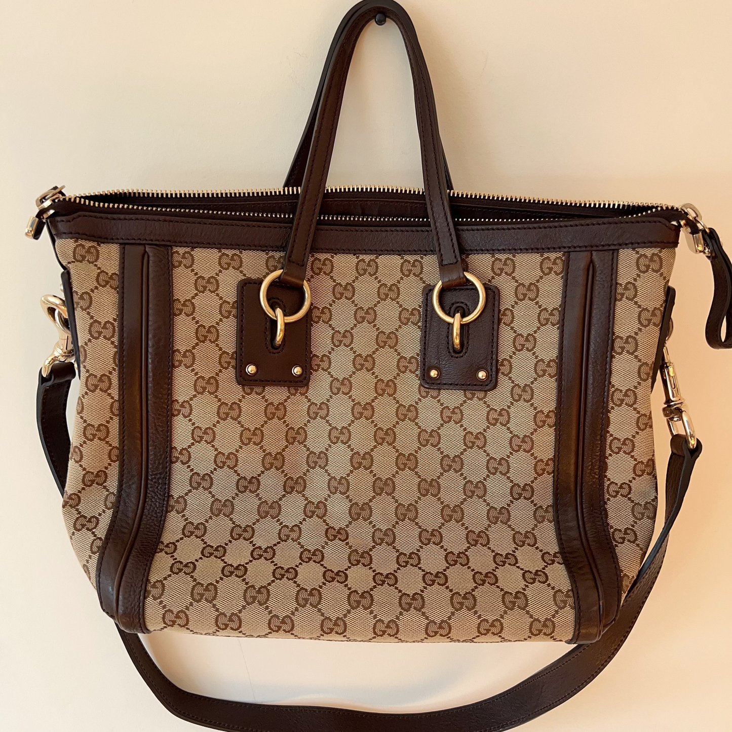 Designer handbag with brown and beige pattern on a light background