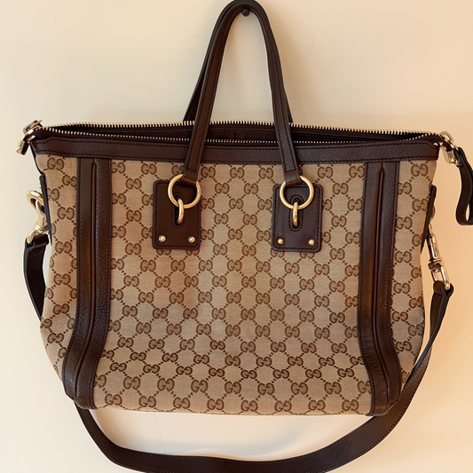 Designer handbag with brown and beige pattern on a light background