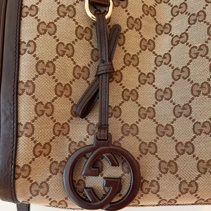 Close-up of a Gucci handbag with monogram pattern and interlocking G logo.