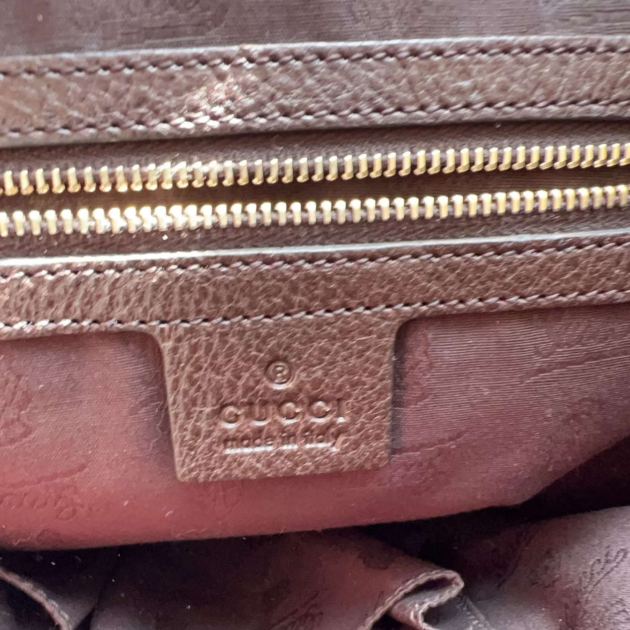 Close-up of a Gucci leather bag with visible branding.