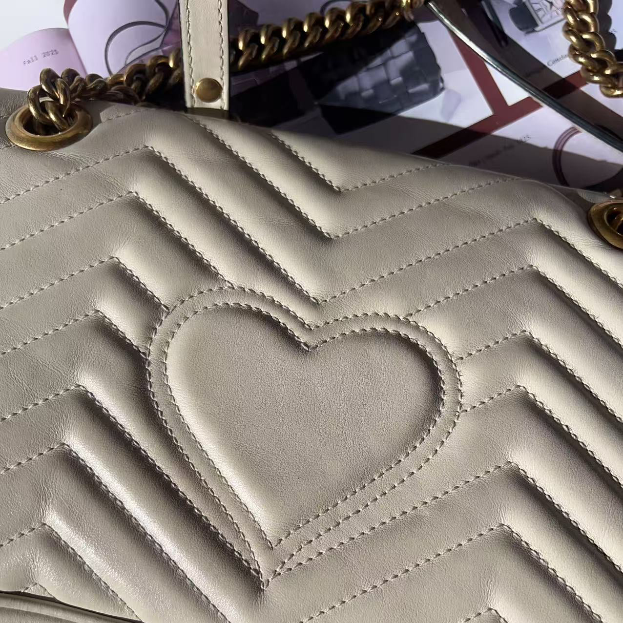 Beige handbag with a heart design and gold chain strap 