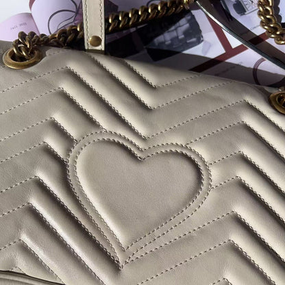 Beige handbag with a heart design and gold chain strap 