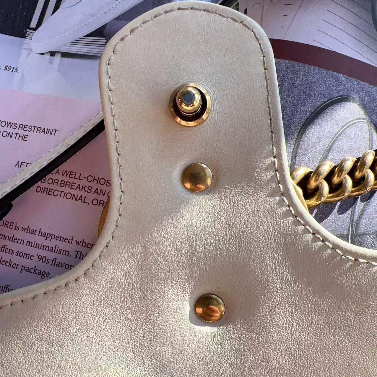 Close-up of a beige handbag with gold hardware