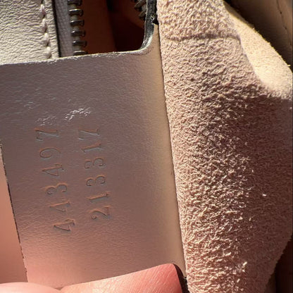 Close-up of a textured leather tag with embossed numbers.