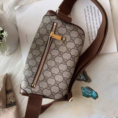 A Gucci monogram canvas shoulder bag with brown leather trim and a gold-tone zipper, styled on a textured cream fabric with a scarf, white rose, and printed paper.