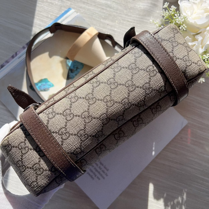 Designer bag with brown and beige pattern on a reflective surface