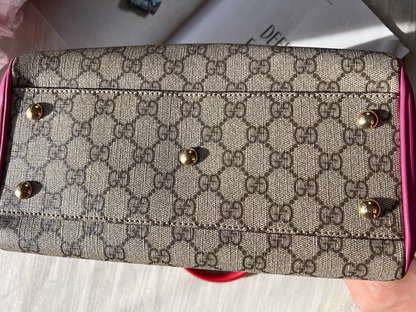 Patterned wallet with pink border held by a hand on a light background