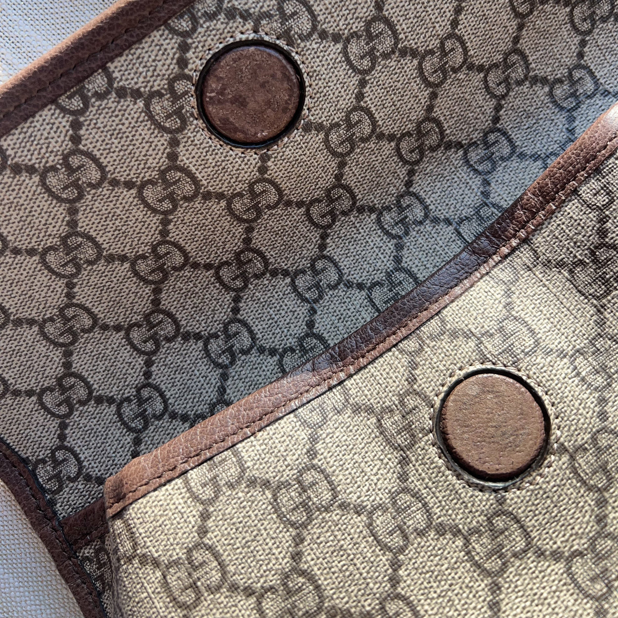 Close-up of a fabric with a pattern and buttons, possibly a bag or garment.