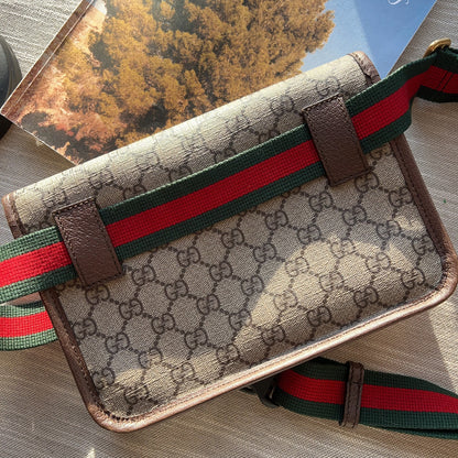 Designer handbag with a distinctive pattern and color stripe on a textured surface