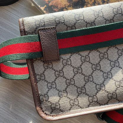 Gucci wallet with iconic monogram and web stripe on a textured surface