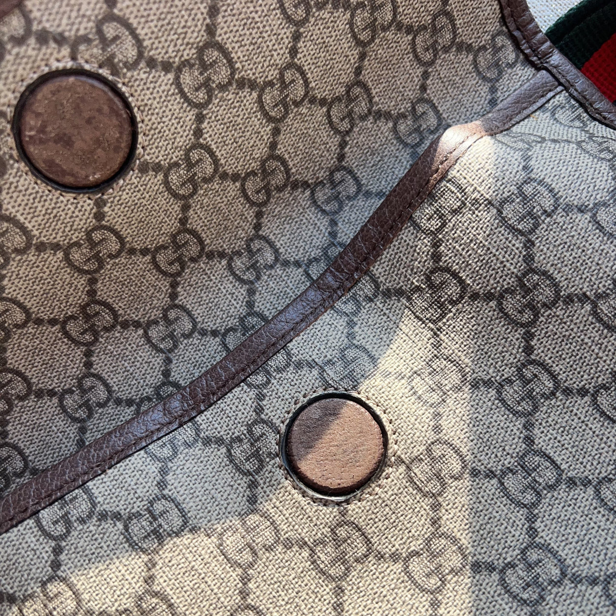 Close-up of a Gucci patterned fabric with two buttons.
