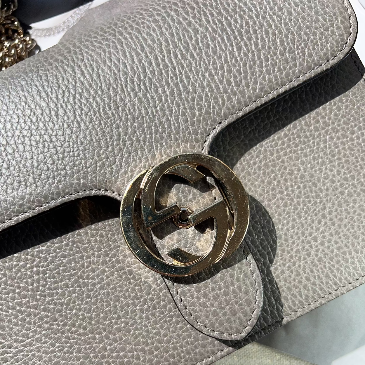 Close-up of a gray textured handbag with a gold interlocking G logo.