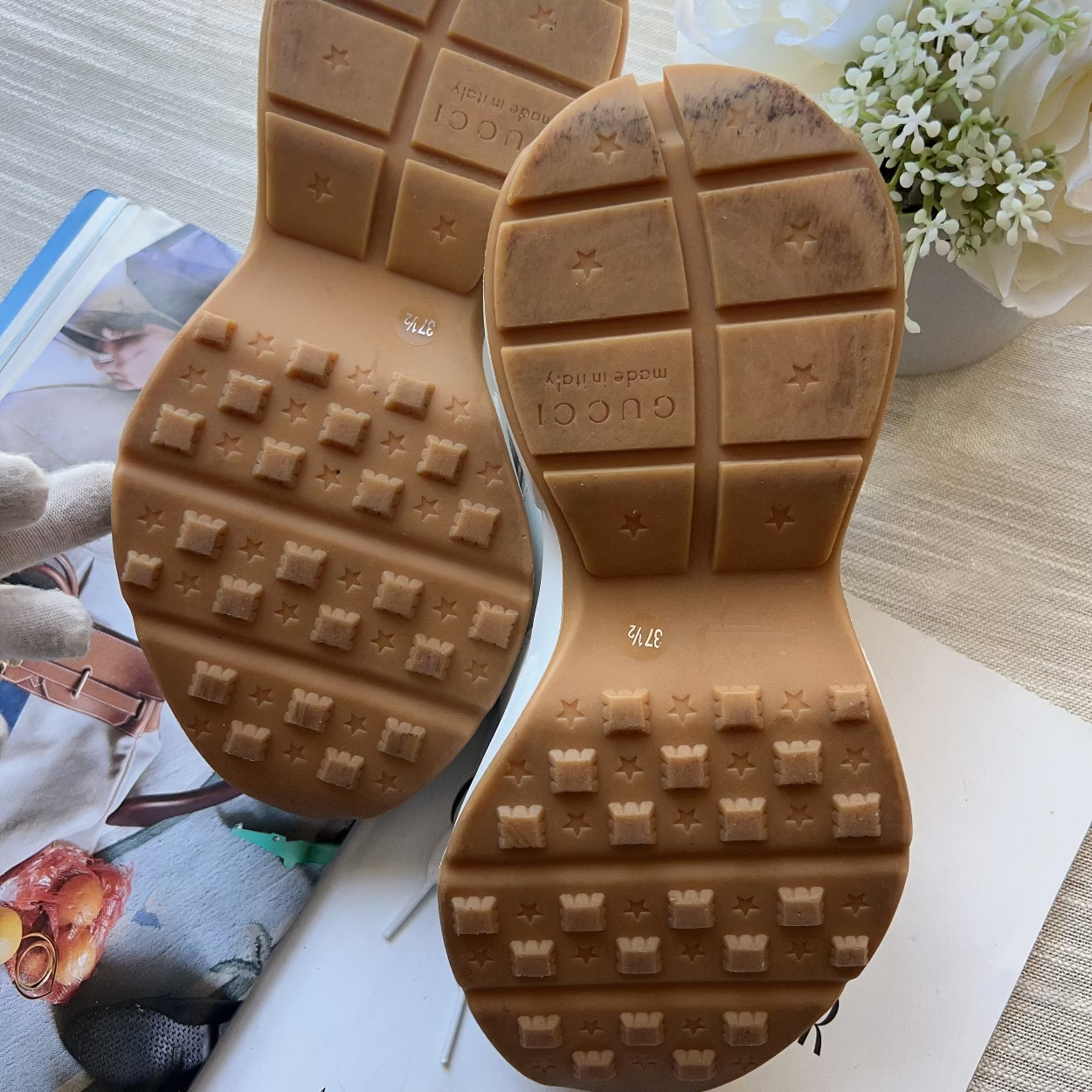 Brown shoe sole with tread pattern on a magazine page with flowers in the background