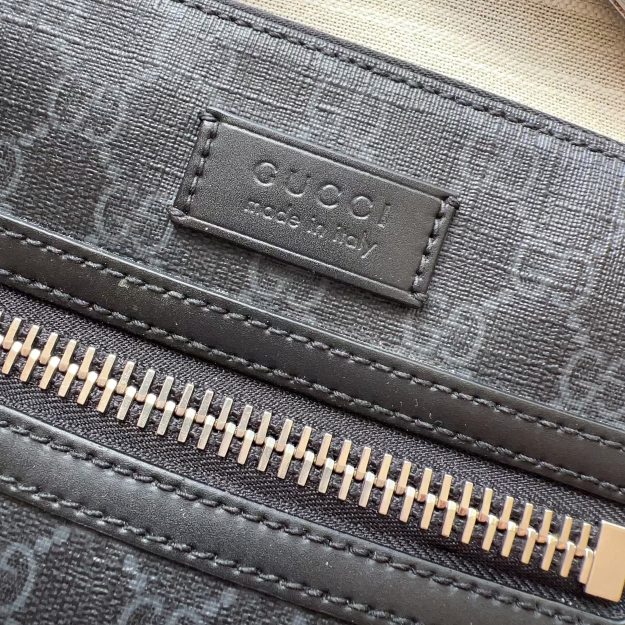 Close-up of a Gucci bag with a visible logo and zipper.