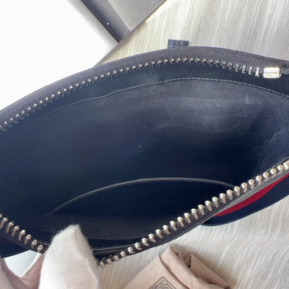 Navy blue handbag with a visible brand logo on a light surface