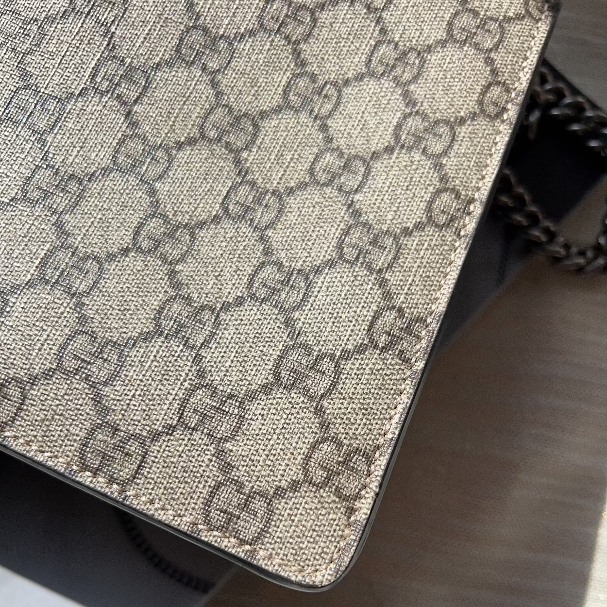 Close-up of a Gucci handbag with a distinctive pattern on a wooden surface