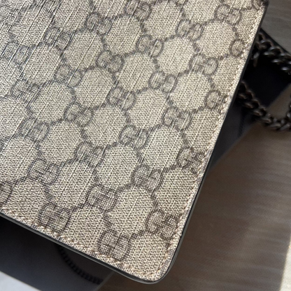 Close-up of a Gucci handbag with a distinctive pattern on a wooden surface