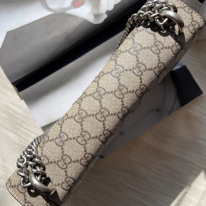 Designer handbag with chain detail on a textured surface