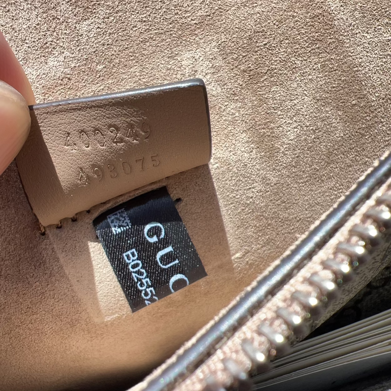 Close-up of a Gucci wallet with visible branding and serial number.