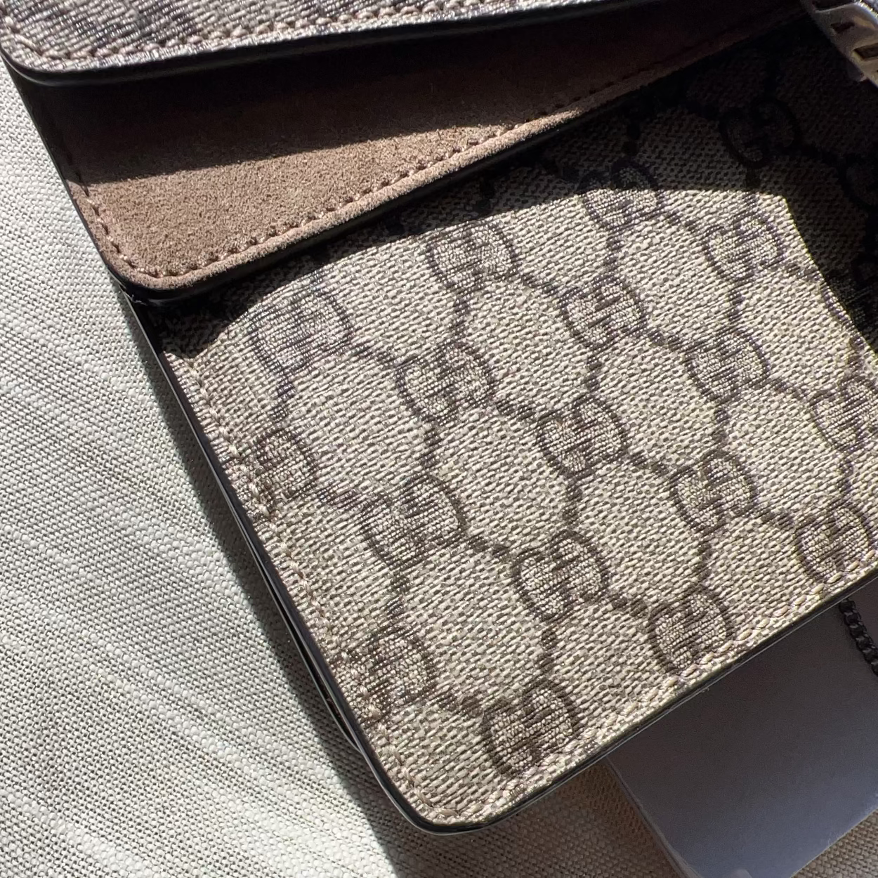 Close-up of a Gucci patterned wallet on a textured surface