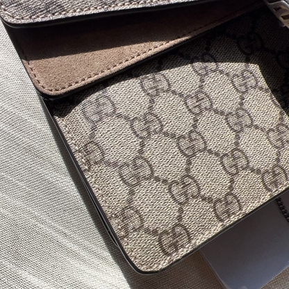 Close-up of a Gucci patterned wallet on a textured surface