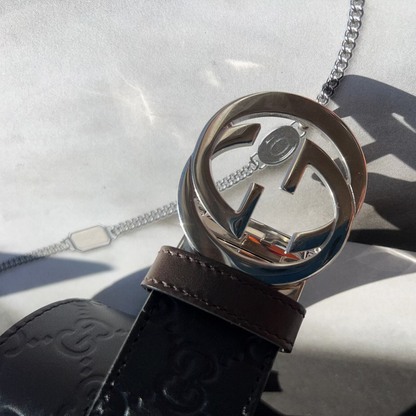 Close-up of a Gucci belt with interlocking G logo on a light background