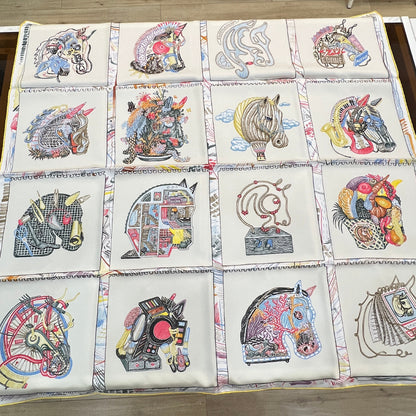Quilt with colorful geometric patterns on a wooden floor.