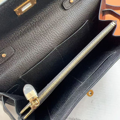 Black leather handbag with gold zipper and hardware on a white background