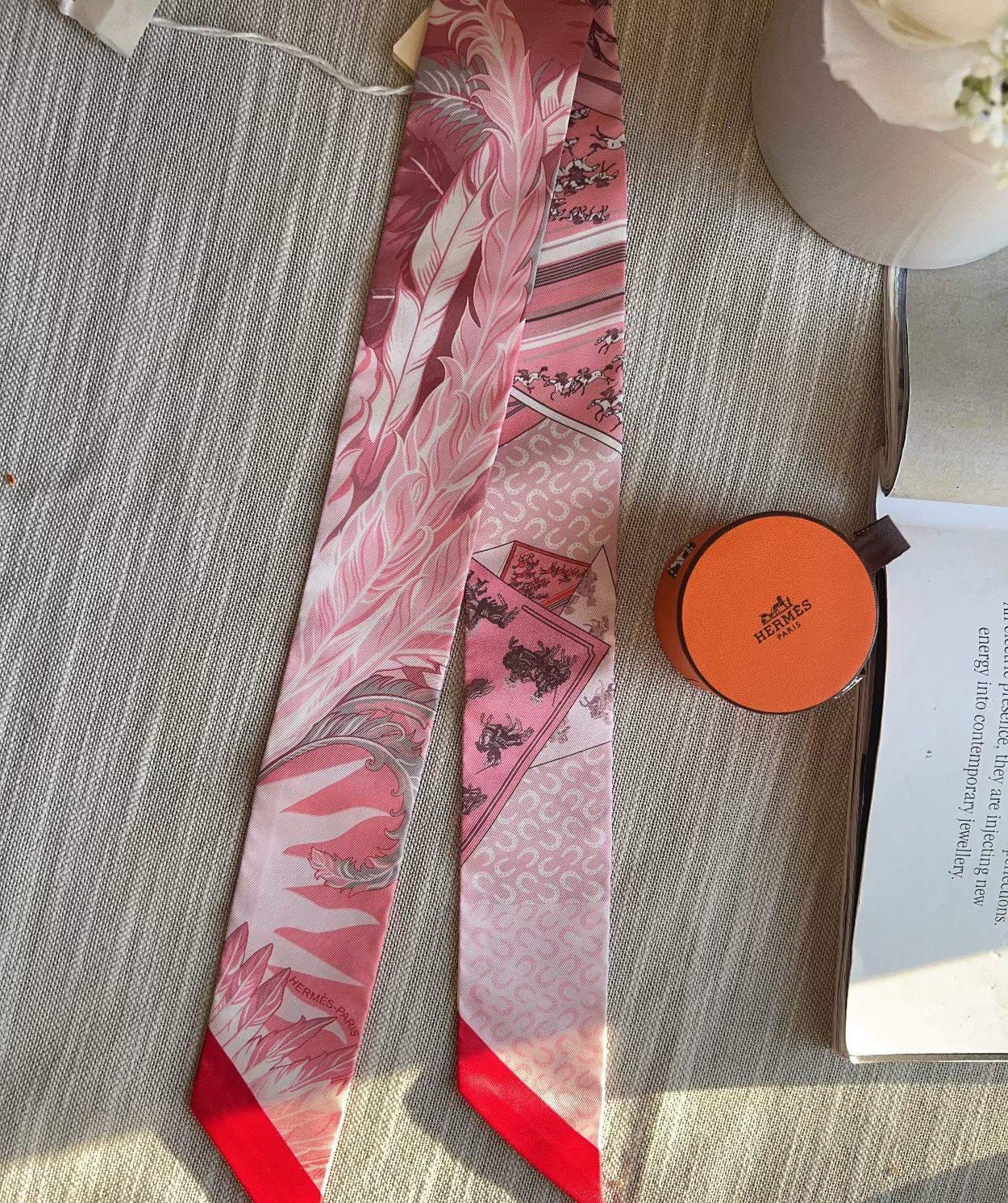 Decorative pink and red ribbon with floral design on a textured surface