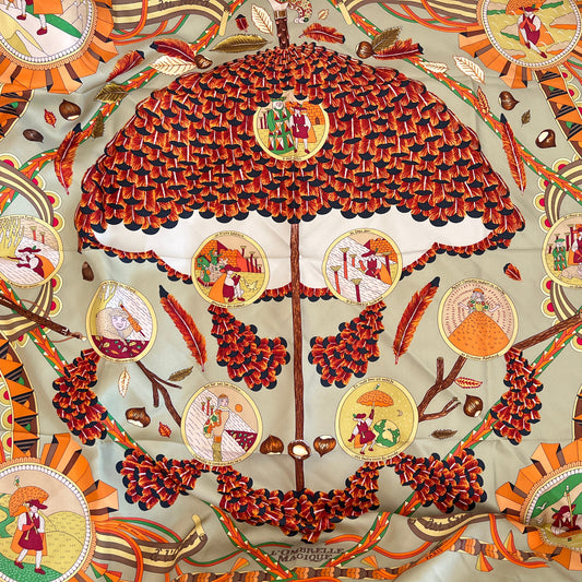 Decorative fabric with intricate patterns and colors, featuring a central design of an umbrella and circular illustrations.