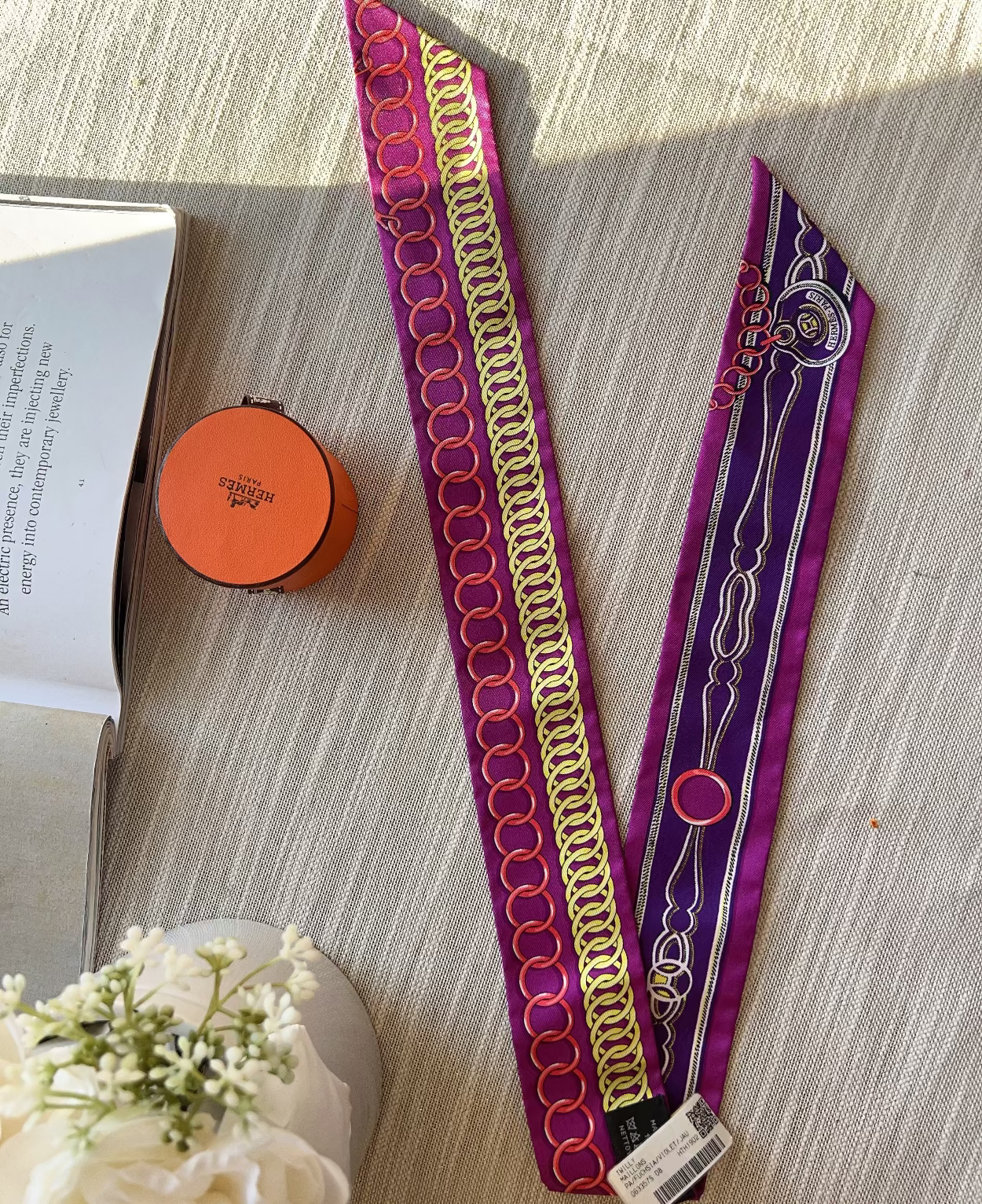 Two decorative headbands on a textured surface with a book and small round object nearby.