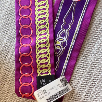 Decorative ribbon with intricate patterns and a visible brand label on a textured surface.