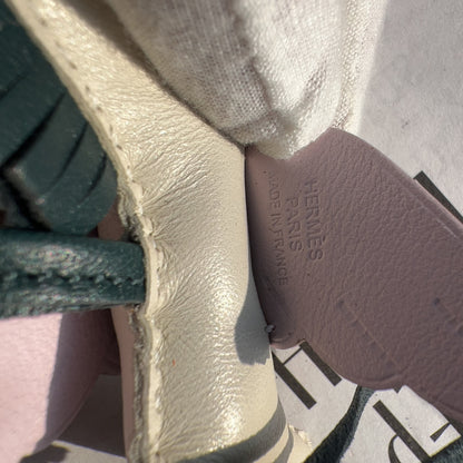 Close-up of a Hermès shoe showing the interior insole with embossed 'HERMÈS PARIS' text and a cream-colored leather strap.