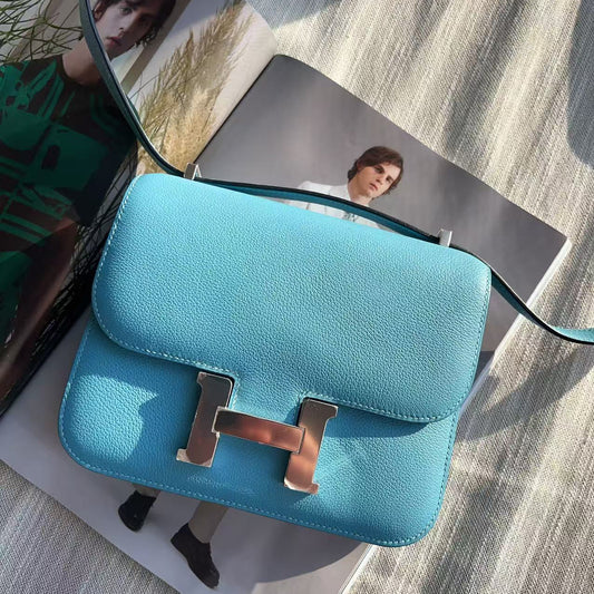 Blue handbag with gold hardware on a textured surface