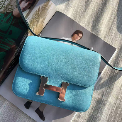 Blue handbag with gold hardware on a textured surface