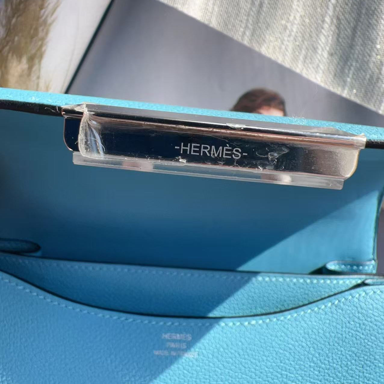 Blue Hermès handbag with visible brand logo.