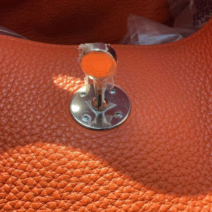 Close-up of an orange textured surface with a metallic clasp.