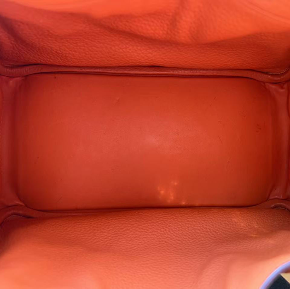 Close-up of an orange leather bag with visible stitching