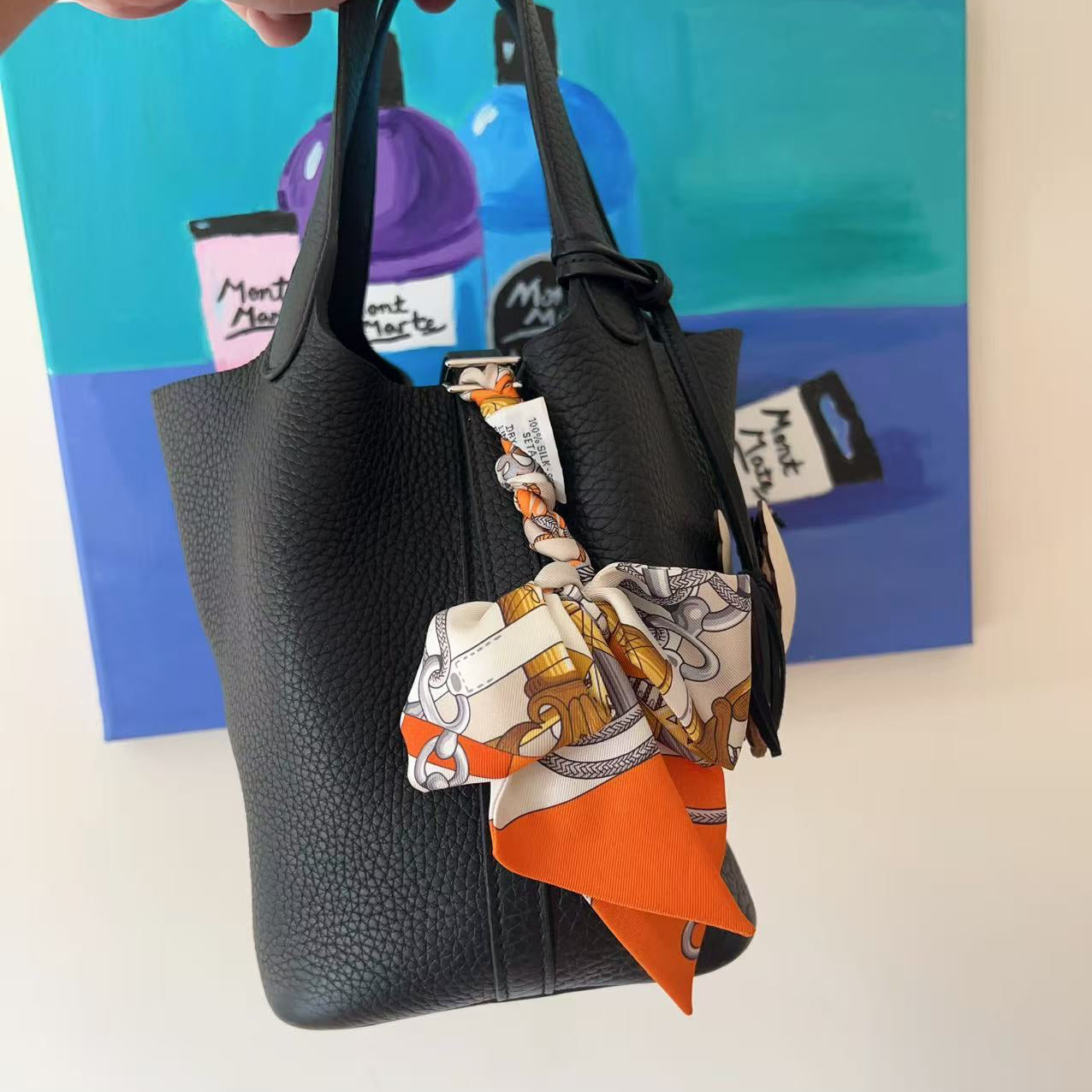 Black handbag with a colorful scarf 