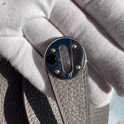 Close-up of a metal buckle on leather with a white fabric background