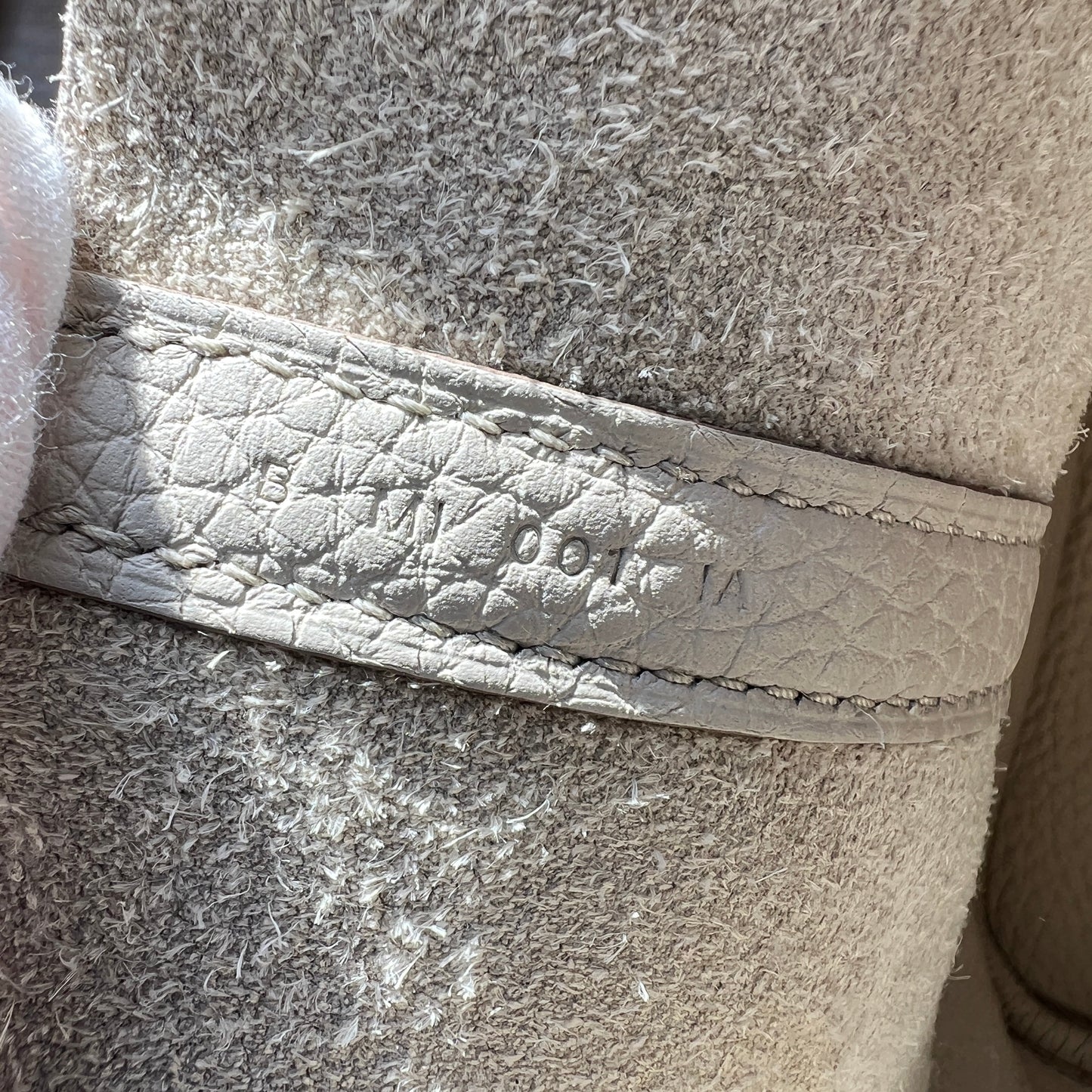 Close-up of a textured fabric surface with a brand logo.