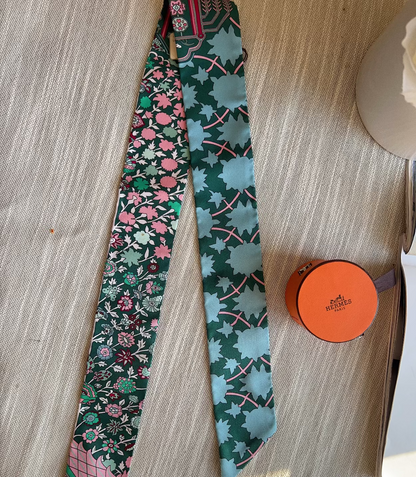 Two patterned ties and a small round box on a wooden surface