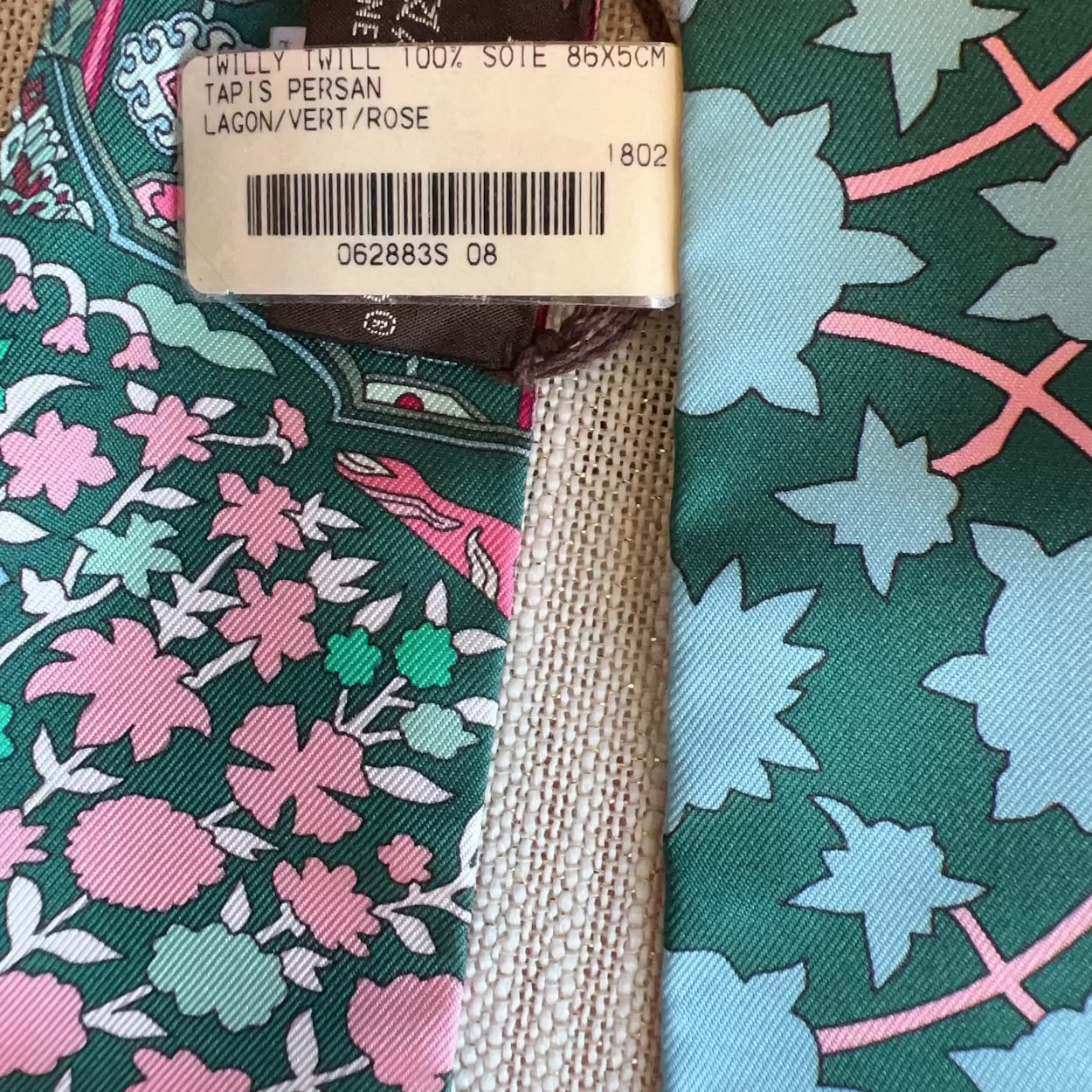 Close-up of a patterned tie with a visible brand tag.