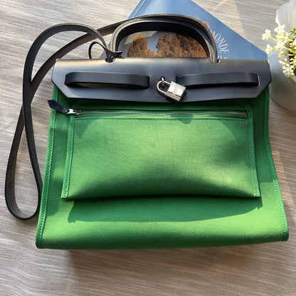 Green handbag with sunglasses on a wooden surface