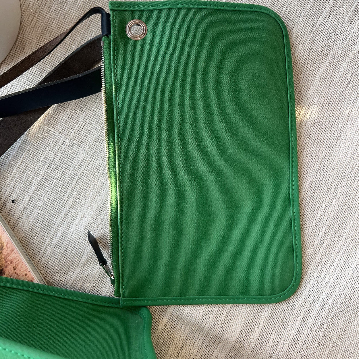 Green leather wallet on a light wooden surface