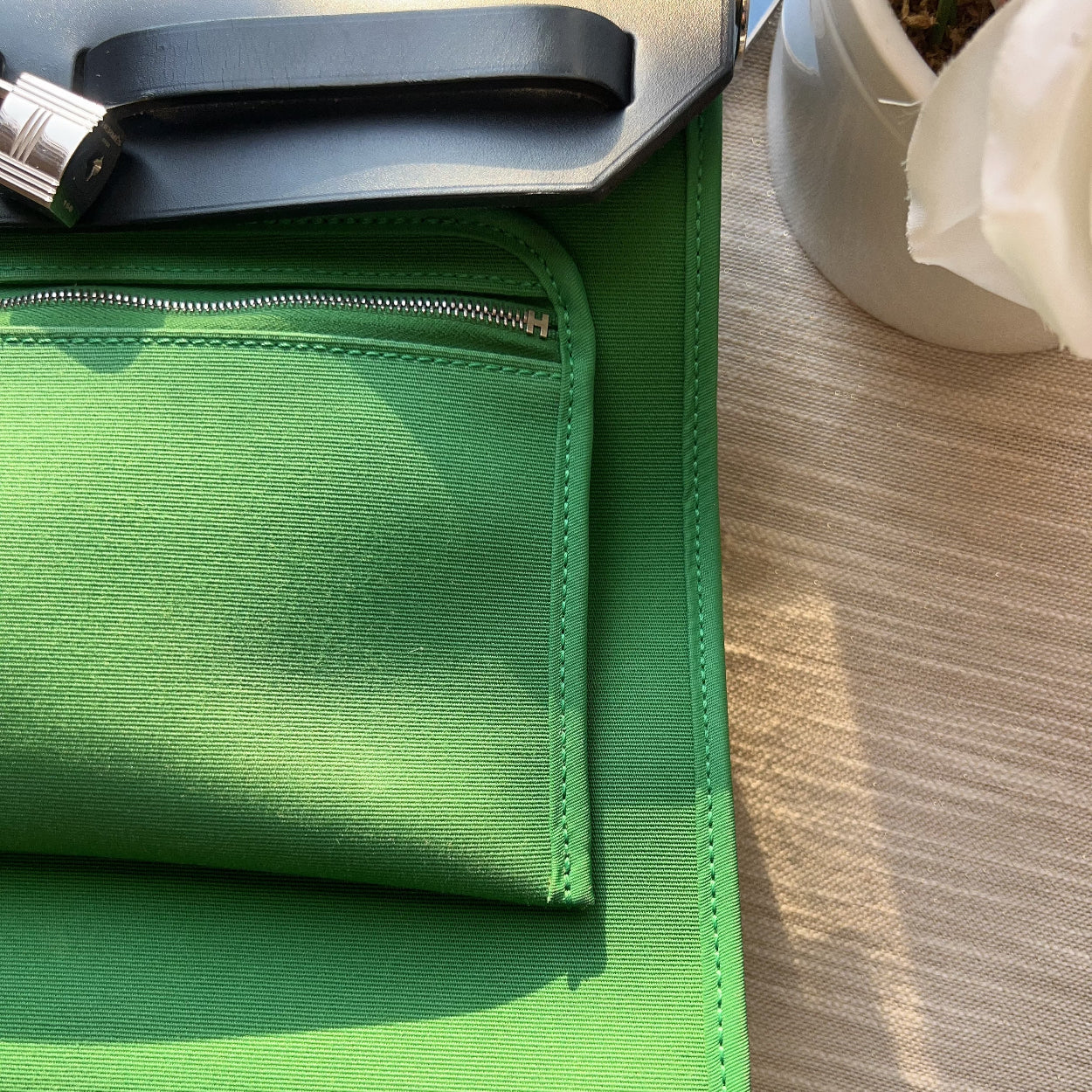 Green fabric on a wooden surface with a plant in the background