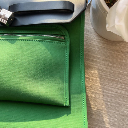 Green fabric on a wooden surface with a plant in the background