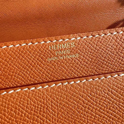 Close-up of a brown leather product with 'Hermes Paris' branding.
